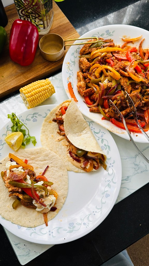Two tortilla wraps filled with fajita chicken, capsicums, red onion, spicy mayo and plain mayo