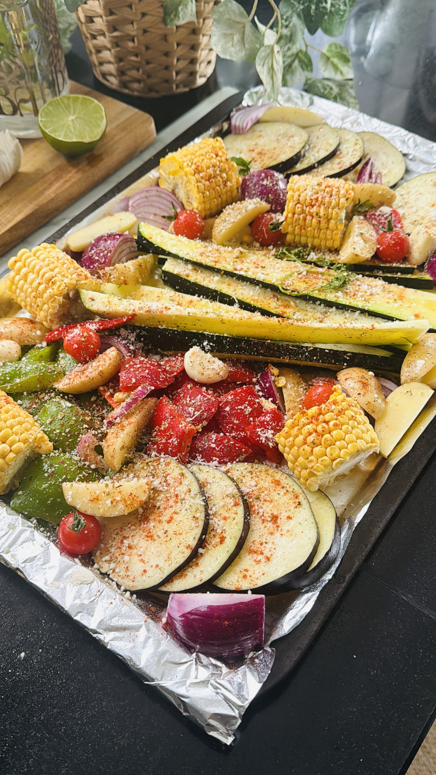 A tray of seasoned vegetables dusted with cheese before baking